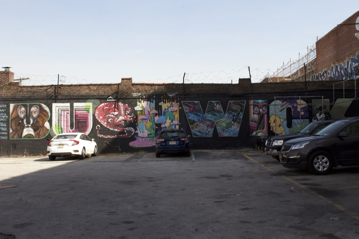 The Bushwick name painted across a wall off a parking lot